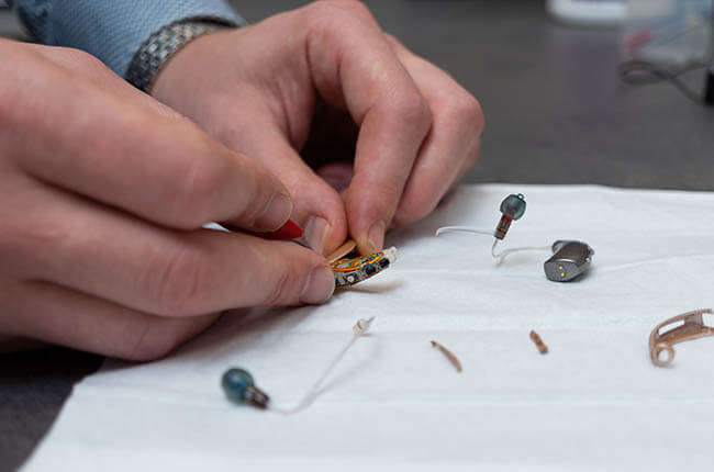 Chris Arnold of Arnold Hearing Centres repairing a hearing aid
