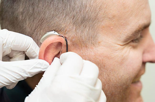 A young man having his hearing aid fitted at Arnold Hearing Centres