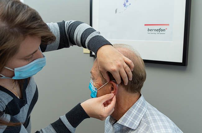A senior gentleman having his hearing aid fitted at Arnold Hearing Centres