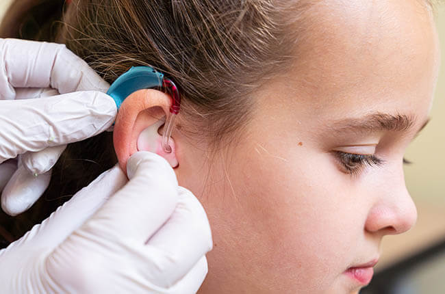 Little girl having a hearing aid fitted at Arnold Hearing Centres